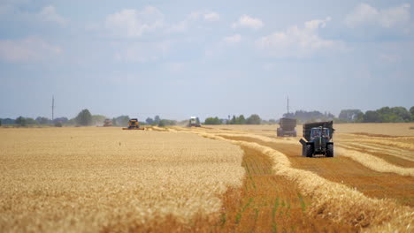 Harvesting crop in the countryside. Seasonal works with industrial technology on field. Agricultural machinery working on yellow field under blue sky.