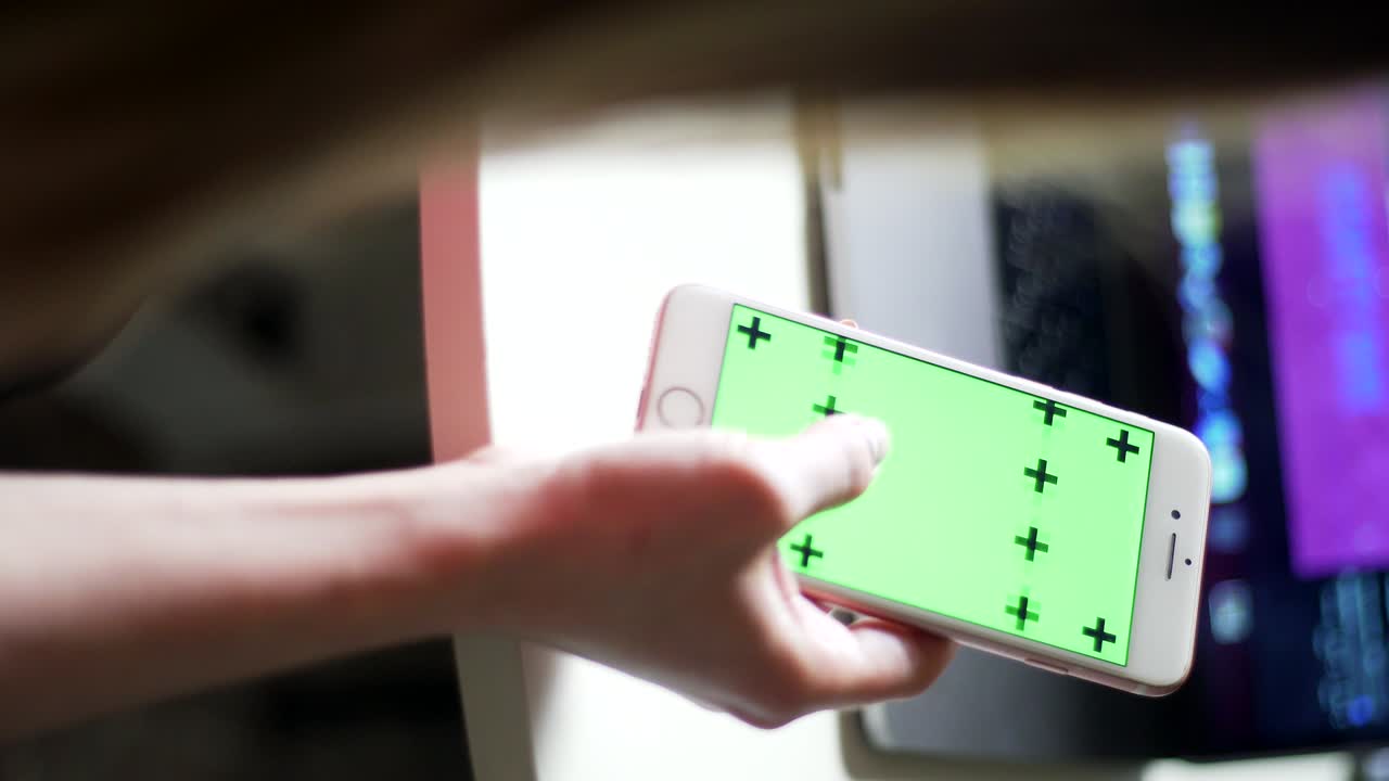 여성 손은 스마트폰에 테이프를 스크롤합니다. 트래커와 함께 녹색 화면