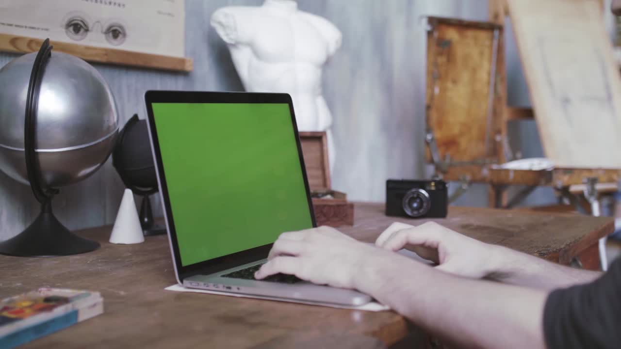 persona trabajando en una computadora portátil en el estudio de un artista