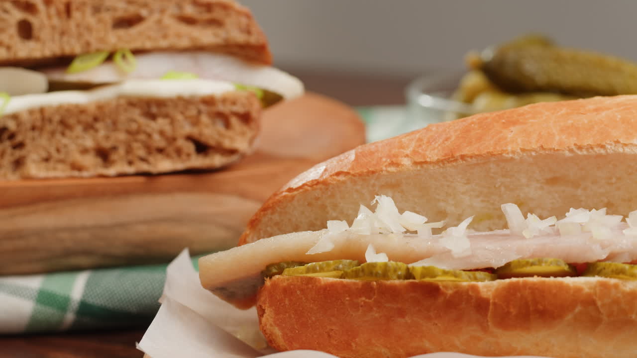 Two types of sandwiches with fish and pickles