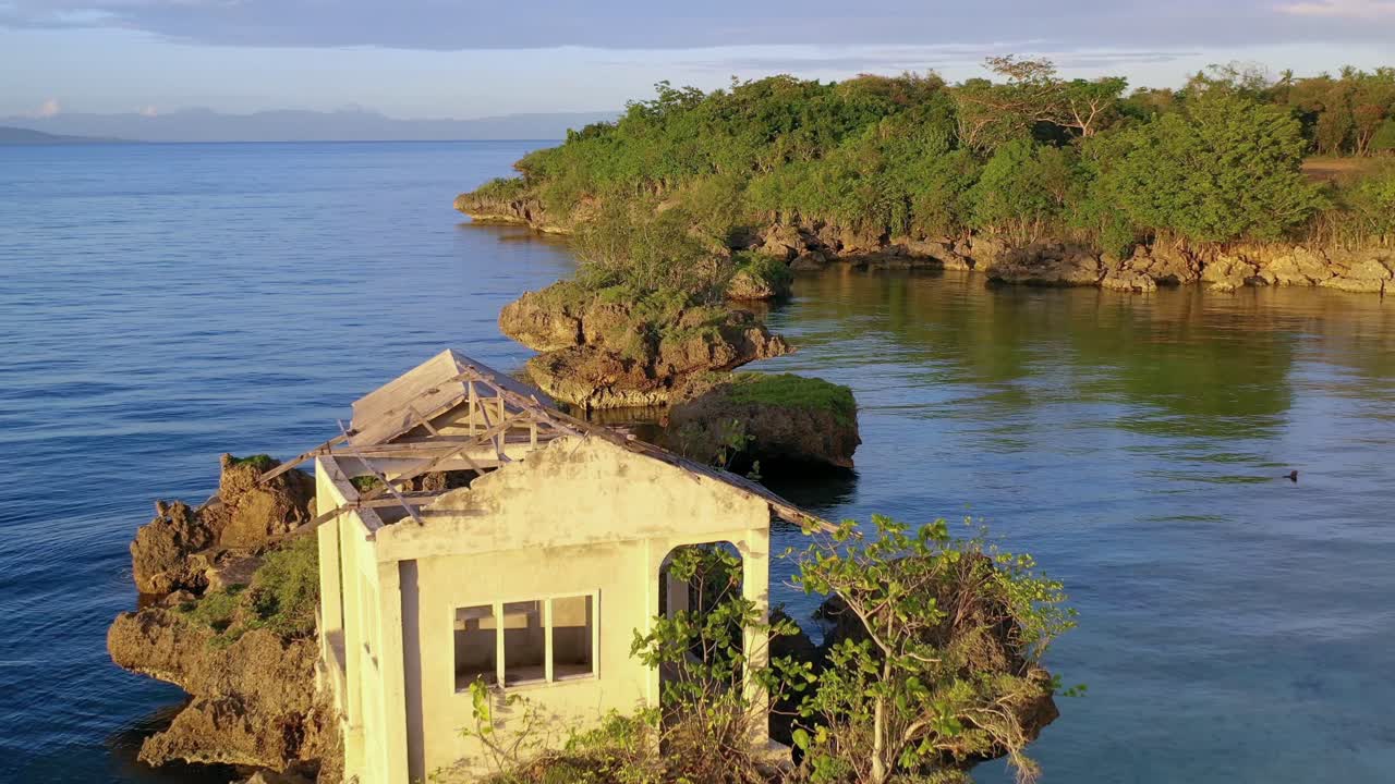 Abandoned house on a rock on beautiful tropical sea shores. Aerial dolly out