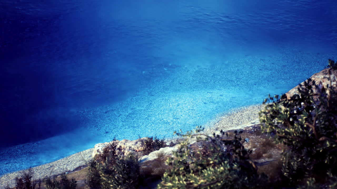 Tranquille acque turchesi e spiaggia di ciottoli sotto un cielo terso