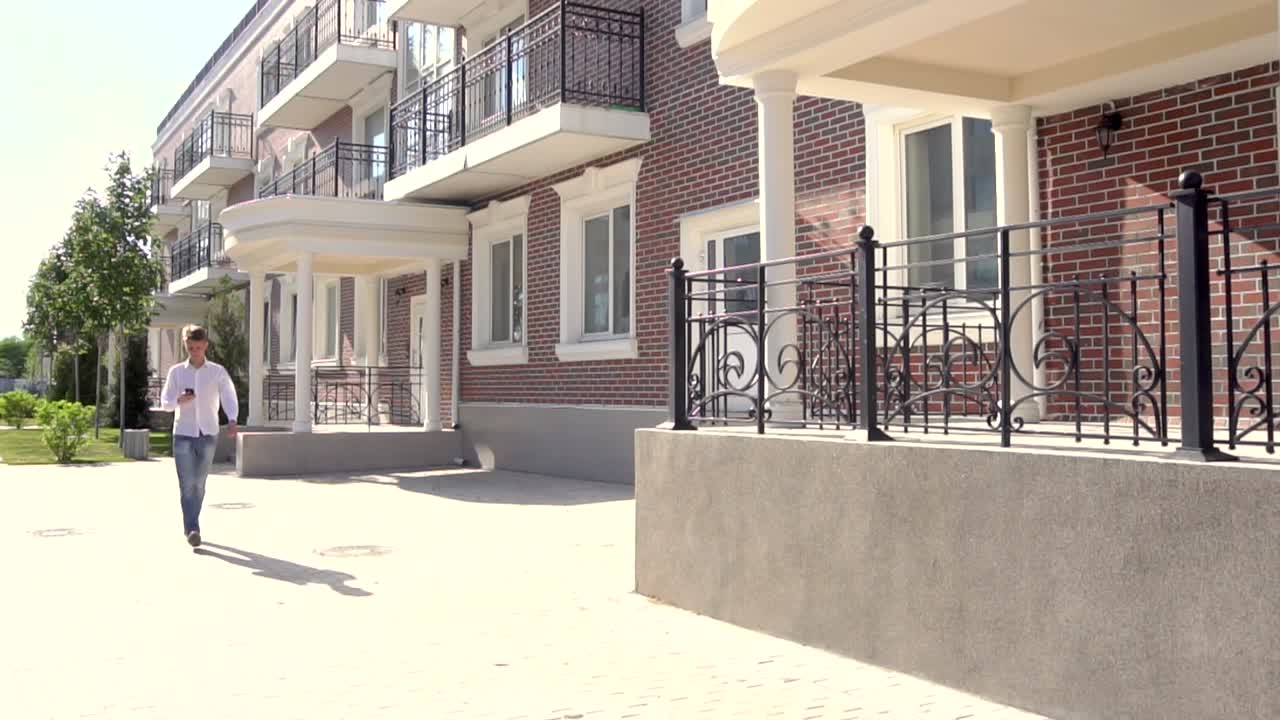 hombre caminando frente a apartamentos modernos