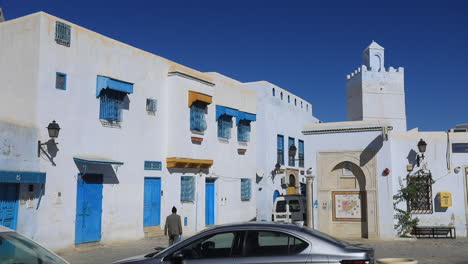 a sunny day in the old town of tunisia with traditional white and blue architecture