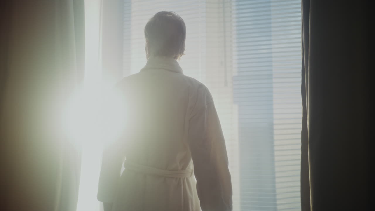 Silver Haired Man Enjoys Soft Sunlight in Stylish Hotel Room (Stock Footage)