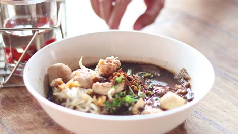 adding final touches to a savory noodle dish