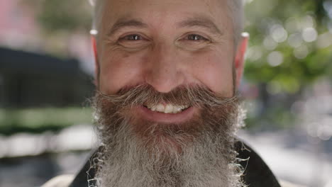 close up portrait of mature sophisticated bearded man smiling cheerful optimistic on city street