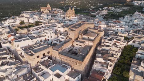 Vista-Aérea-De-Una-Ciudad-Mediterránea-De-Ostuni-Con-Arquitectura-Histórica-Y-Una-Noria.