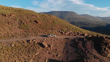 AERIAL---Truck-in-dusty-road,-Caviahue,-Argentina-Patagonia,-slow-motion-truck-right