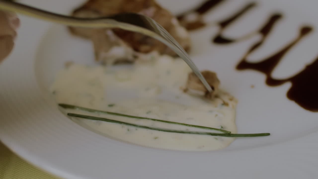 женщина ест мясо в ресторане.