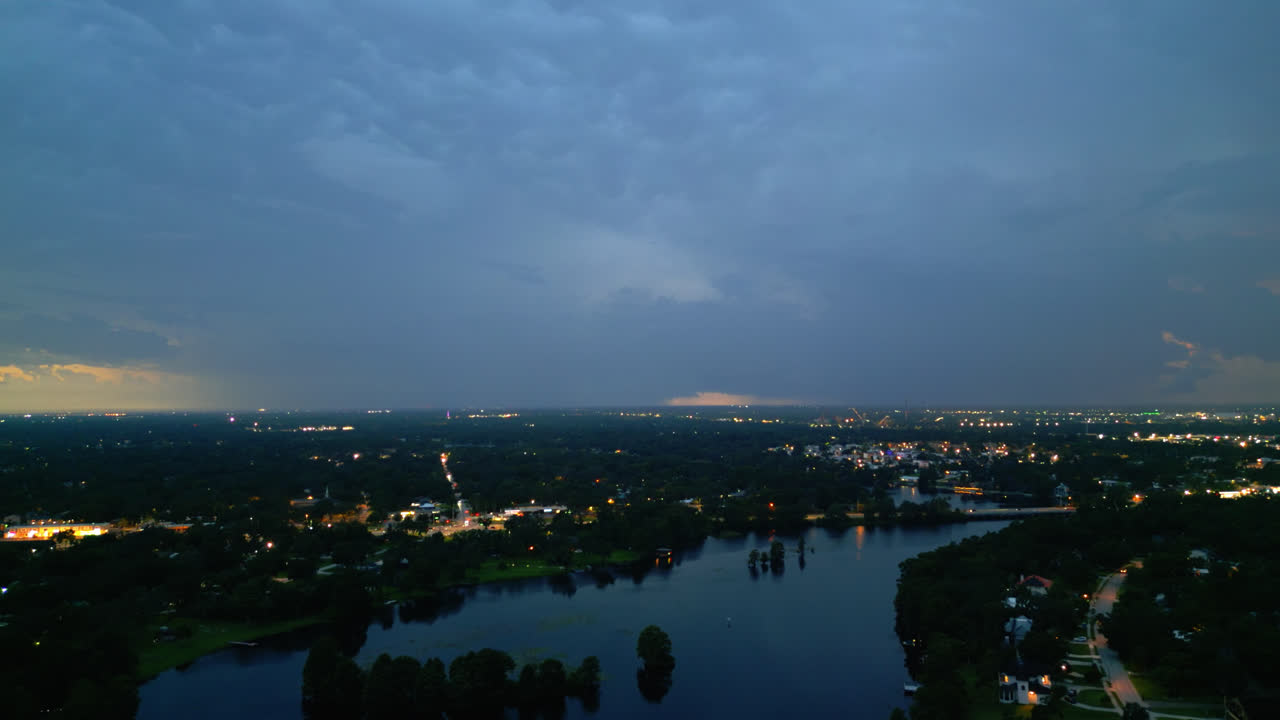 Aerial night view of a lightning storm raging in Tampa with bright sky flashes over the dark city skyline