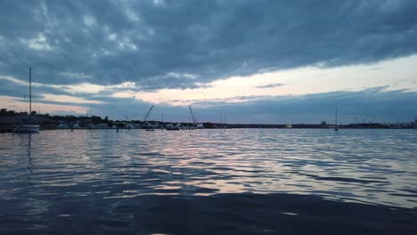 Lake-or-ocean-harbor-at-sunset-boats-and-yachts-in-the-distance