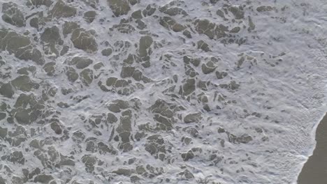 aerial shots of breaking waves on a hazy summer morning in malibu, california