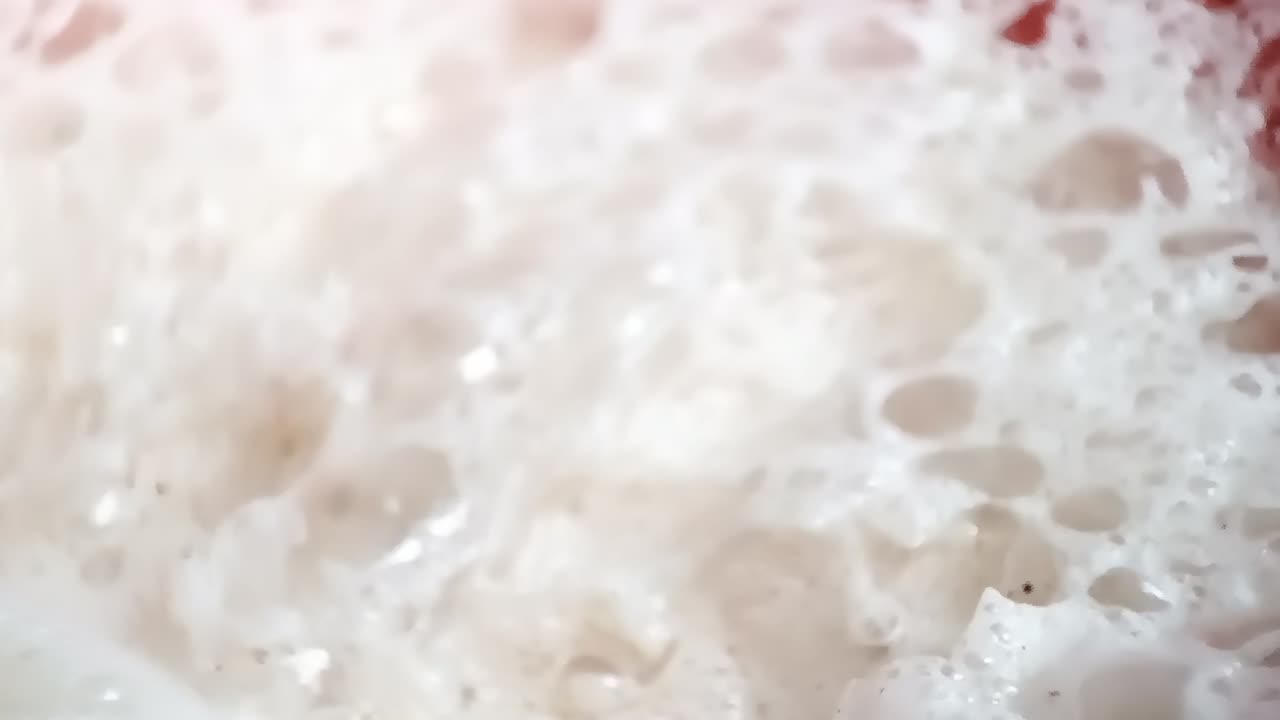 Milk foam on a chai cup, being removed by a spoon