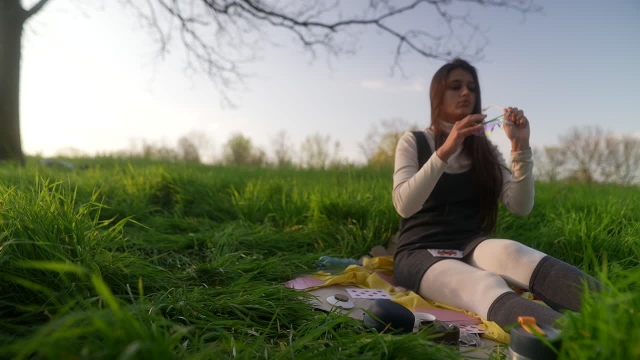 Woman relaxing in a park on a picnic blanket