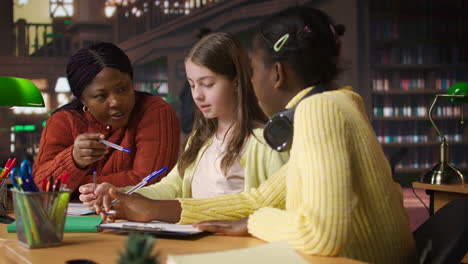 teacher assisting students in library