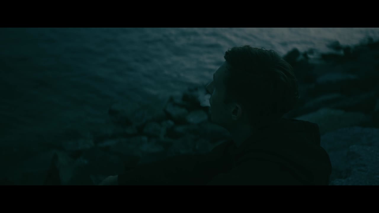 Man Smoking by the Ocean at Night