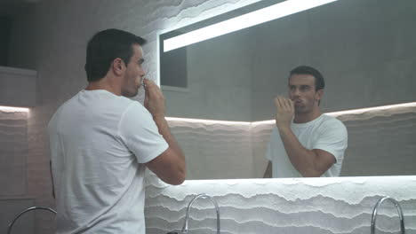 happy man cleaning tooth with brush in bathroom. handsome person carrying tooth.