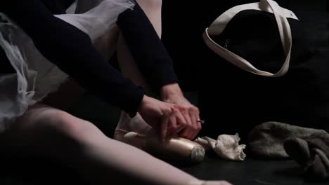 Ballerina-putting-her-pointe-shoe-on