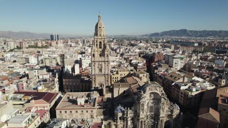 Drone-flying-toward-bell-tower-of-Murcia-Cathedral-with-cityscape,-Spain