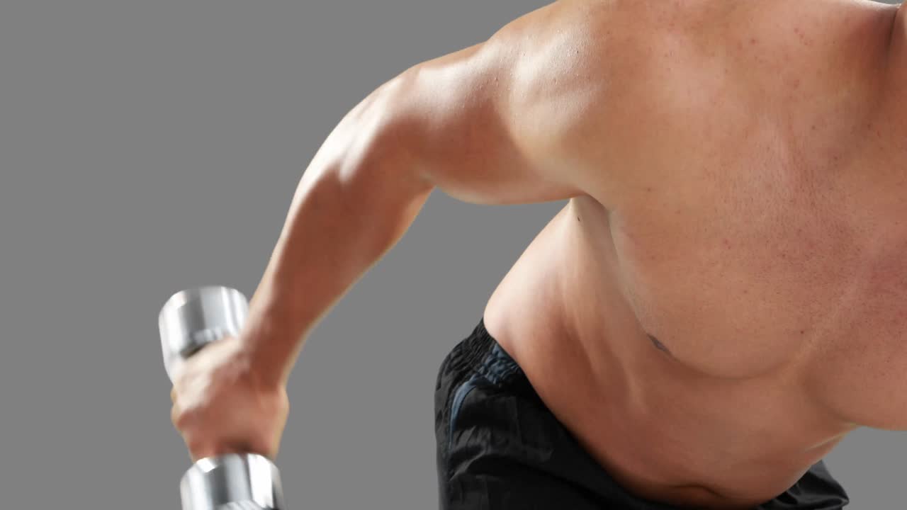 심각한 근육 남자가 덤벨을 들어 올리고 있습니다.