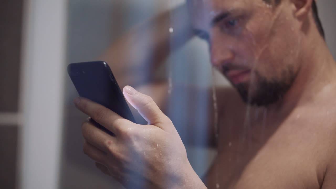 Man using smartphone in shower