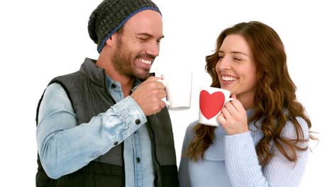 attractive young couple in warm clothes holding mugs