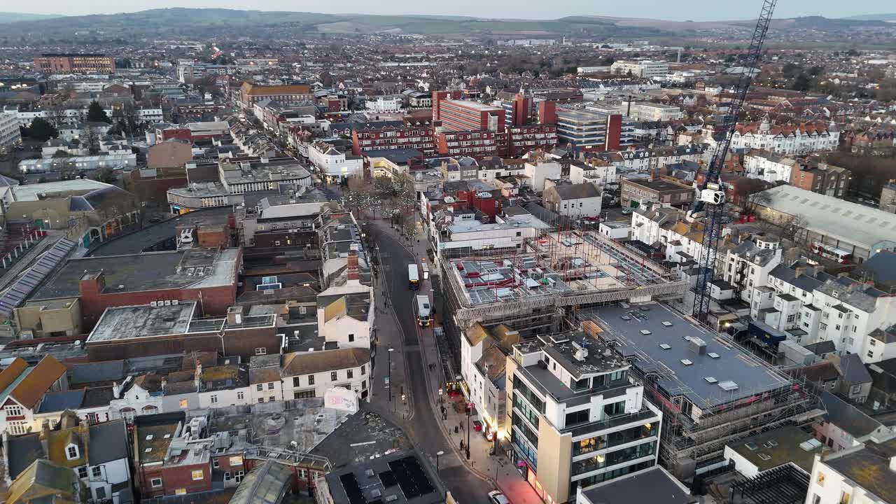 Droneoptagelser fra luften af Worthing, Sussex, Storbritannien, der bevæger sig fra strandpromenaden ind mod byens centrum. Fanger strandaktivitet, gader, hustage og byens puls i skarpe, filmiske detaljer.
