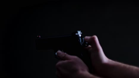 hand-cocking-hammer-of-9mm-pistol-of-firing-a-single-shot-in-a-dark-room