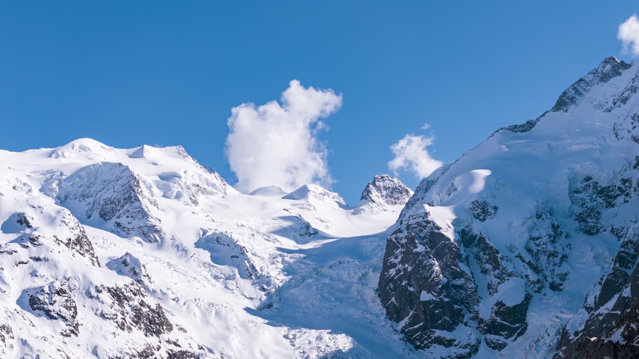 Cime innevate e ghiacciaio del Morteratsch formano un incontaminato paesaggio alpino sotto un cielo azzurro brillante. Hyperlapse