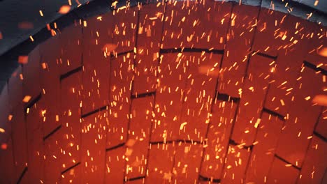 blast furnace in a factory with burning sparks from the fire. burning sawdust in the furnace close up