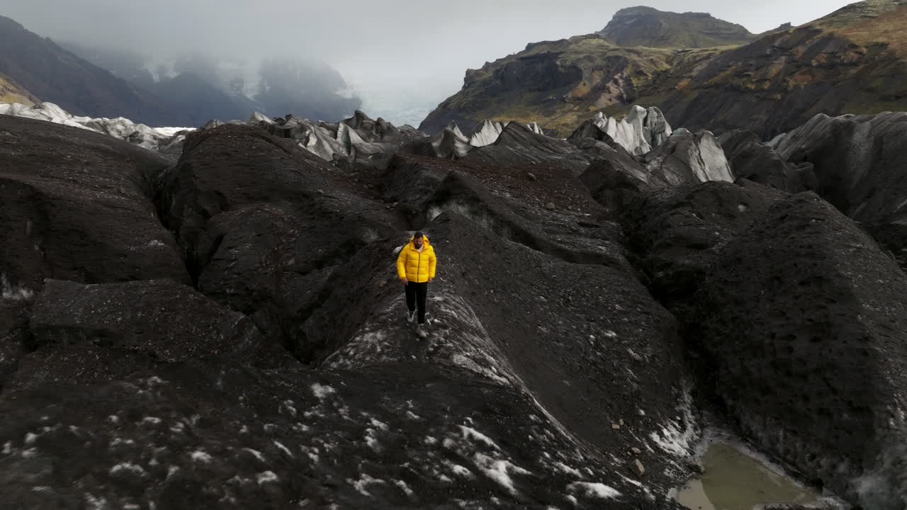 glaciar svinafellsjokull, islandia - un hombre caminando sobre un glaciar - retirada aérea