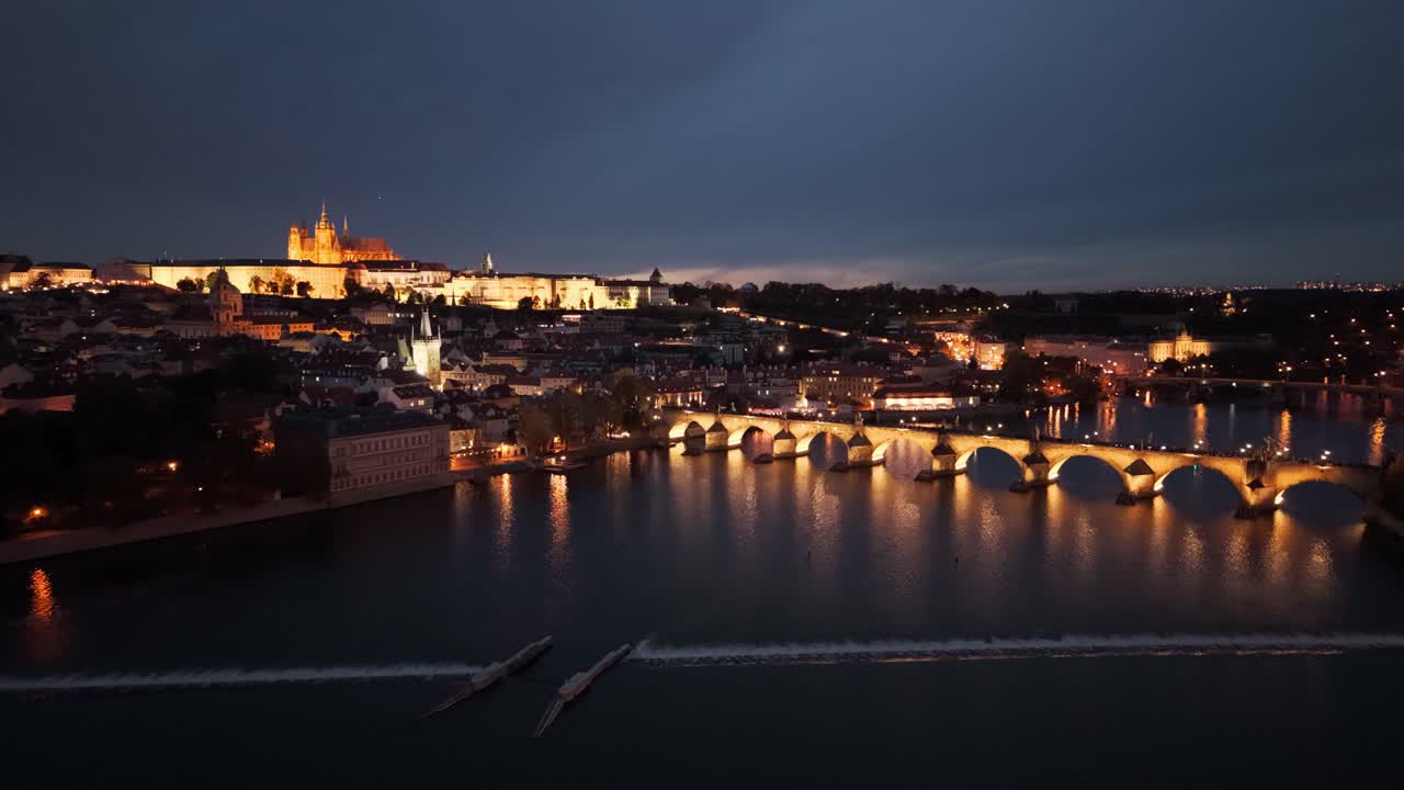 Aerial night view of Charles Bridge and Prague Castle over Vltava River, Czech Republic
