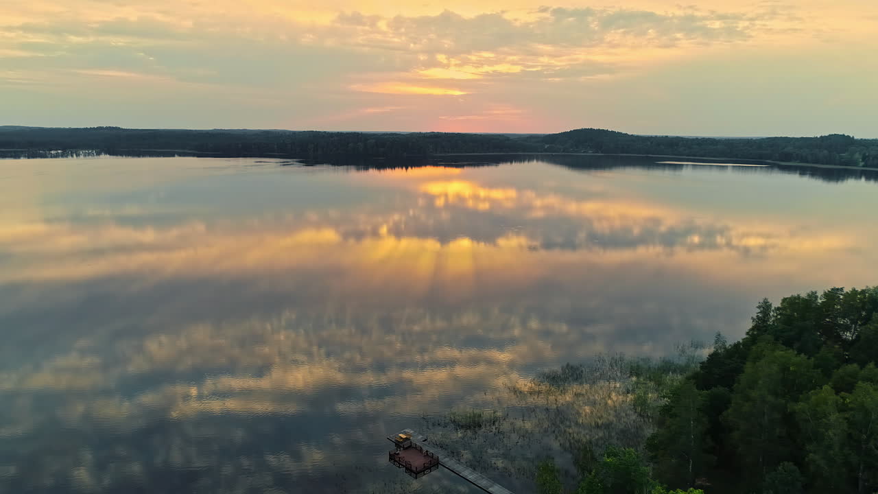 빛을 반사하는 잔잔한 표면과 부두가 있는 호수