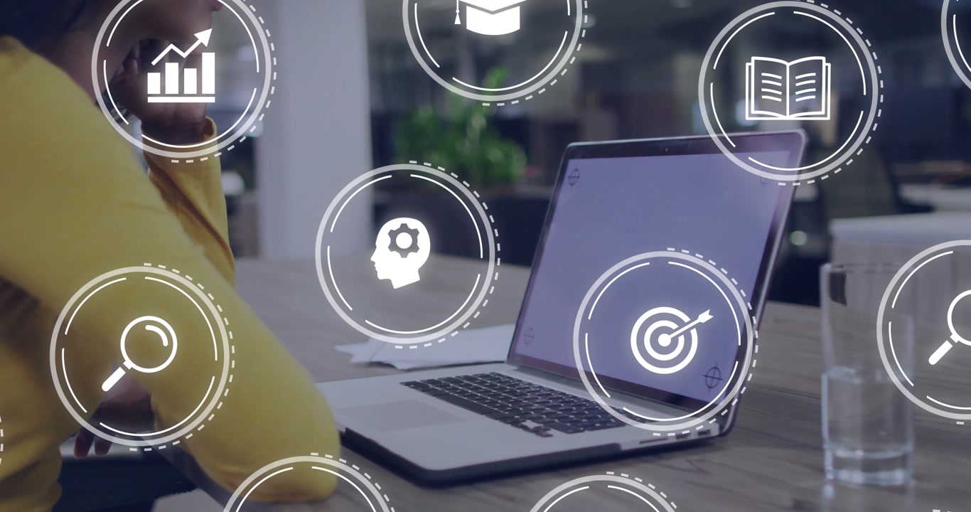Woman leaning on hand at laptop after pausing, watching animated research learning icons swirling