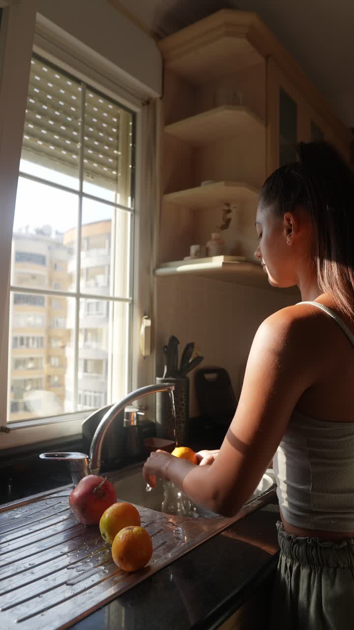mujer lavando frutas en una cocina