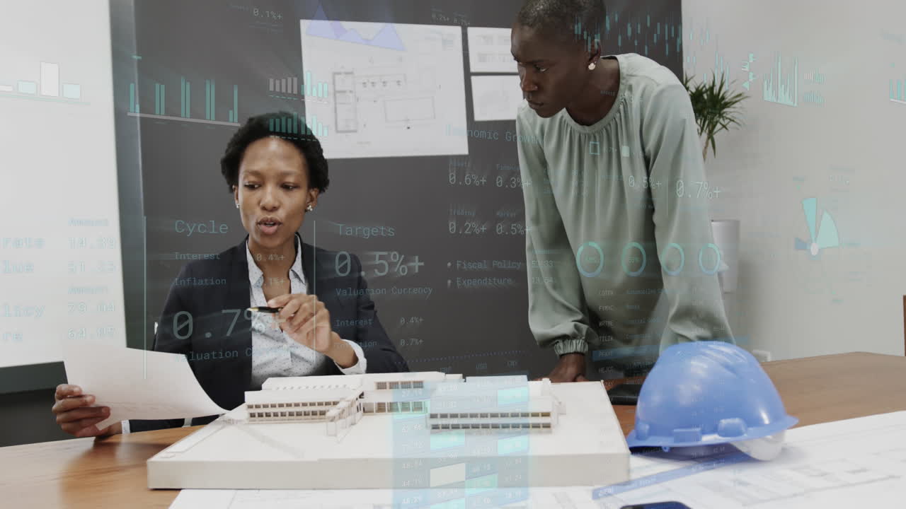 Animation of graphs and changing numbers, diverse female architects discussing 3d model of building