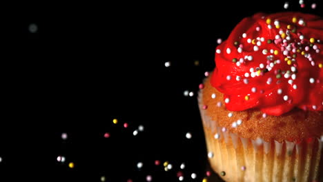 sprinkles falling onto a cupcake