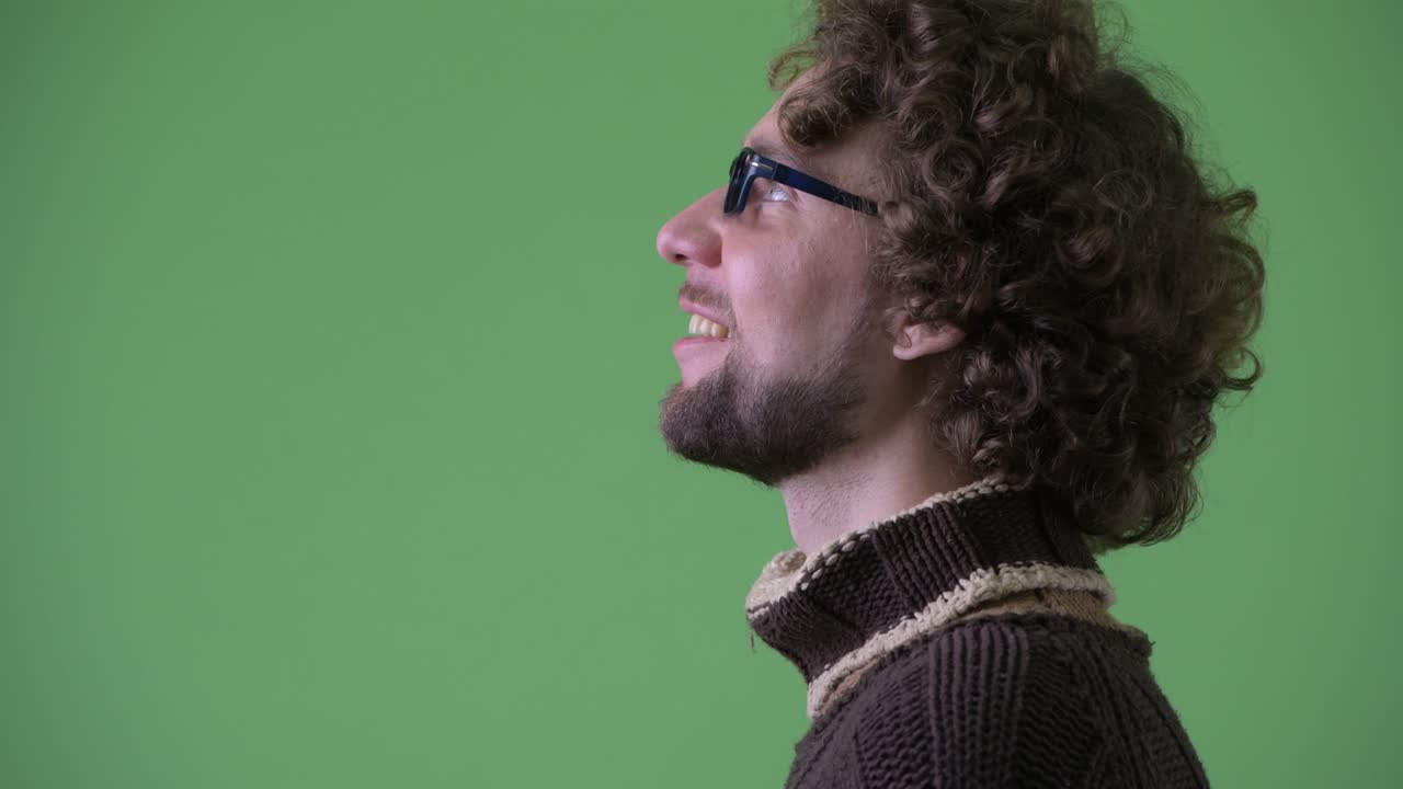 un joven guapo con barba y cabello rizado.