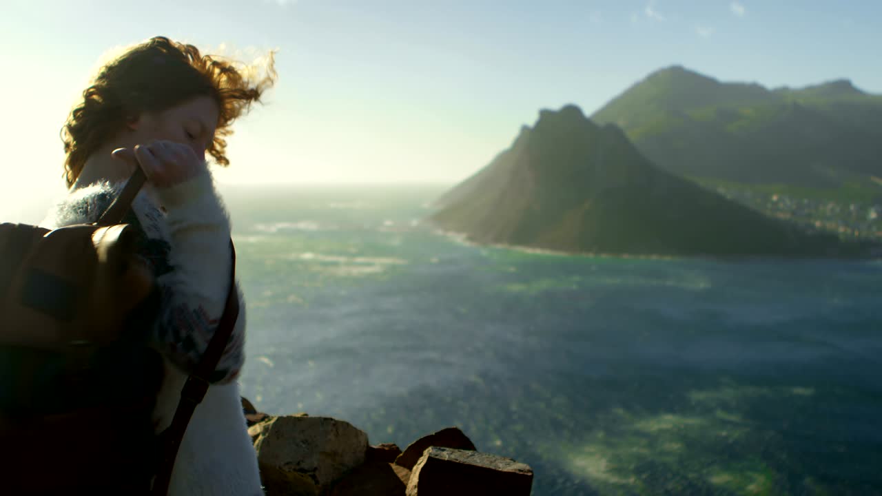 Frau steht mit Rucksack am Meer 4K