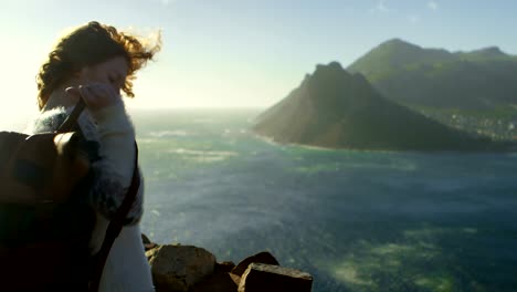 woman standing with backpack near a sea 4k