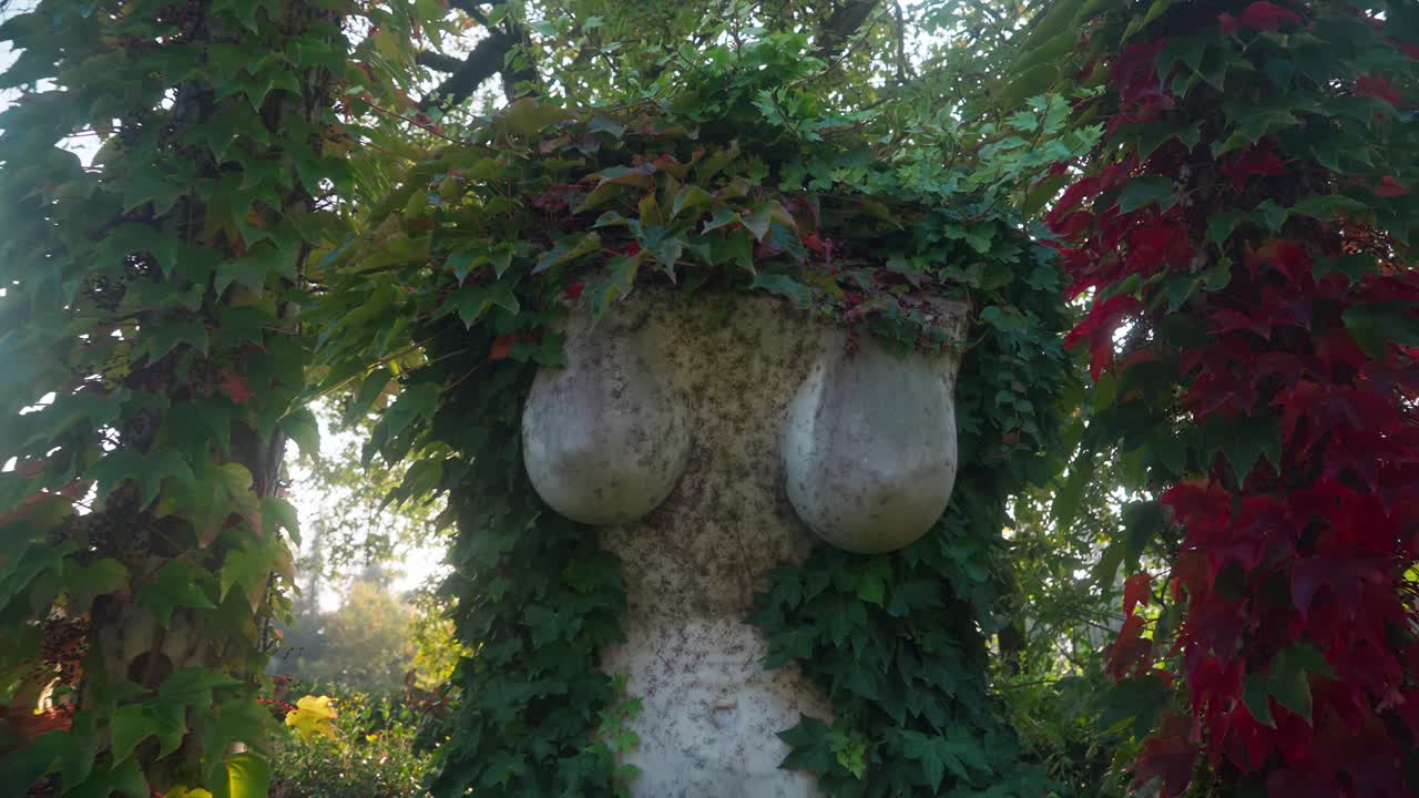 Sculpture of a headless woman’s body covered by red leaves and nature at Lake Iseo, Italy (Lago d’Iseo), near Montisola, Isola di Loreto, and Isola di San Paolo