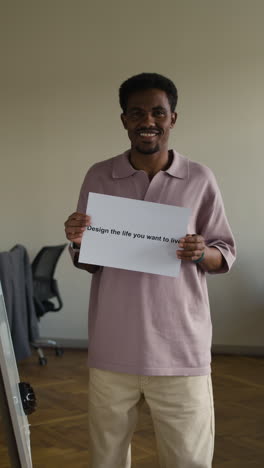 man holding 'design the life you want to live' sign