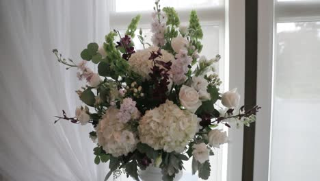 beautiful flower bouquet surrounded by elegant white drapery and stunning windows filled with sunlight