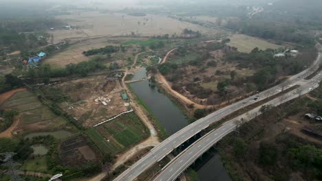 aerial view of highway and bridge crossing a river in a rural landscape