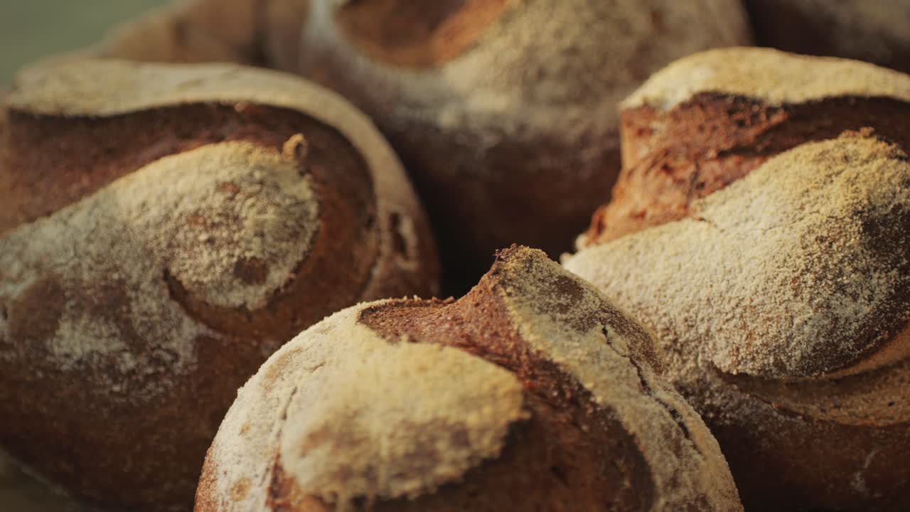 Fresh artesian bread on bakery shop close-up. Bread with black poppy garnish on top and white flour on top. Artisan bread is making by skill bakers using natural and high-quality ingredients. Food with health and flavour benefits.