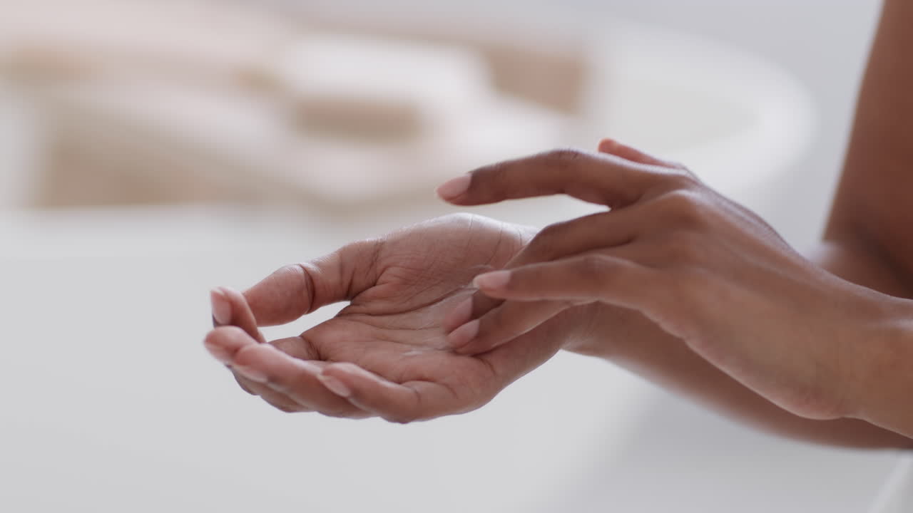 mujer aplicando loción en sus manos