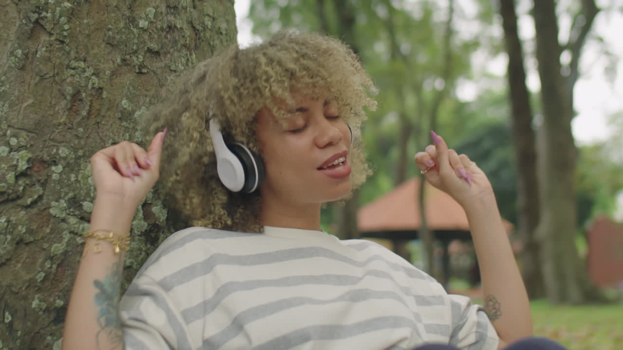 Girl in Headphones Enjoying Music in Park