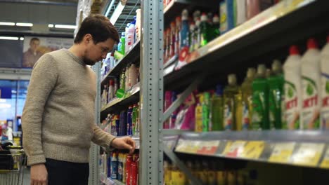 hombre comprando suministros de limpieza en un supermercado