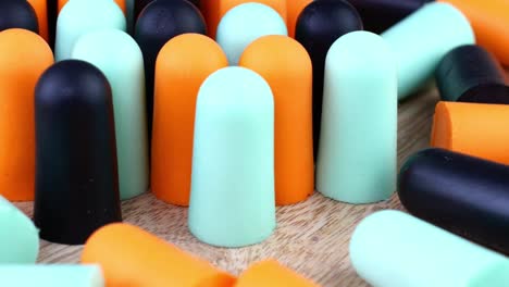 heap many soft orange, blue and black earplugs protect against loud noise and help sleep peacefully.